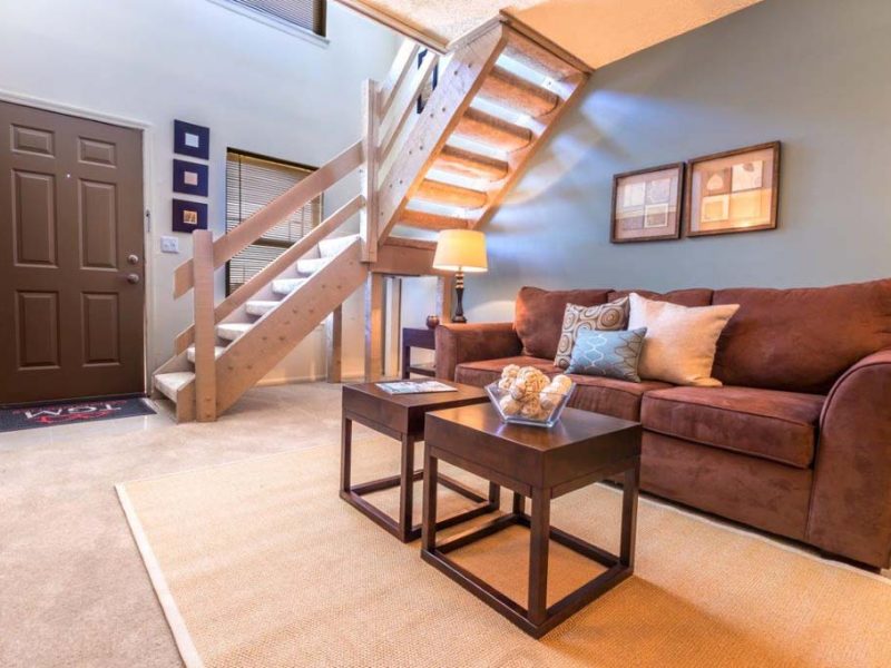 This image shows the premium feature inside the living room area, a staircase near the front door leads to a large sleeping loft overlooking the living room.
